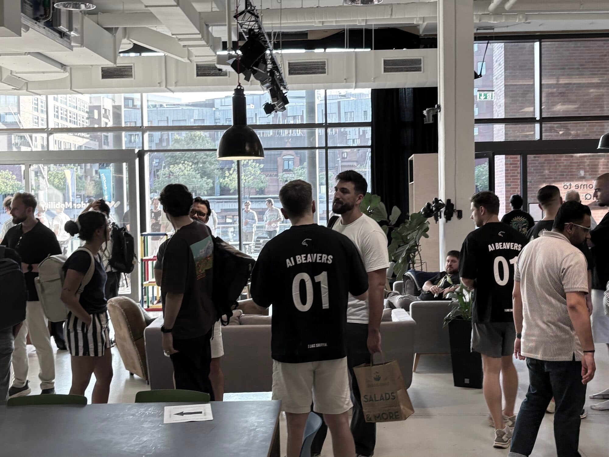 AI BEAVERS hosts seen from behind in black jerseys with the number 01, moving through a busy event