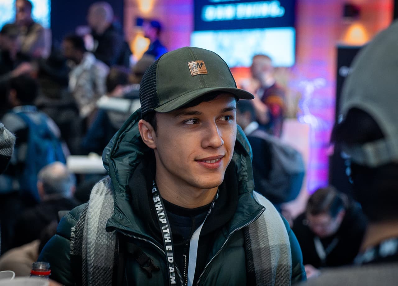 A young builder in a green cap smiling in the crowd at the AI BEAVERS January 2026 hackathon in Hamburg
