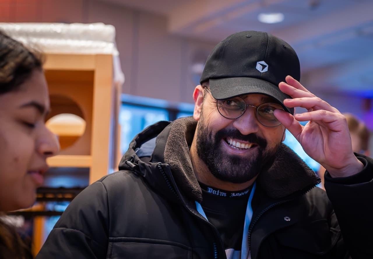 An attendee in a black cap laughing on arrival at the AI BEAVERS January 2026 hackathon in Hamburg
