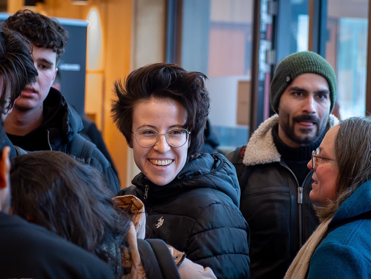 A group of attendees in winter jackets smiling as they arrive at the AI BEAVERS January 2026 hackathon in Hamburg