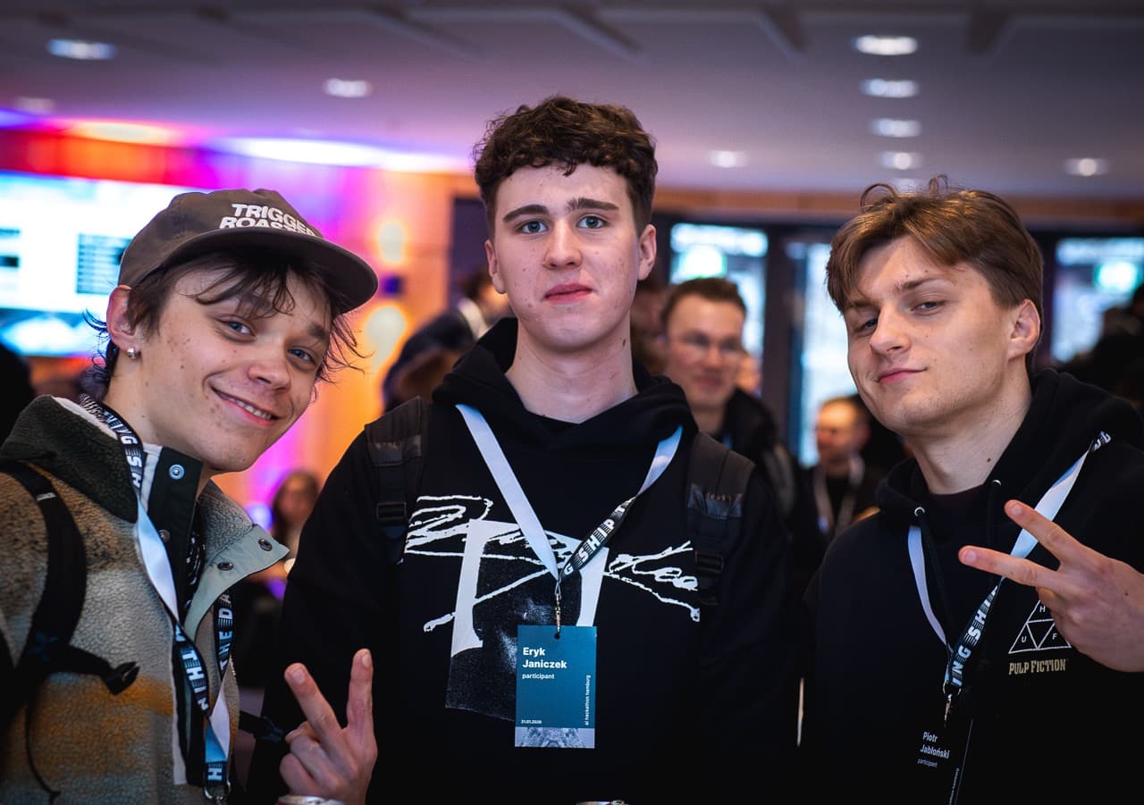 Three young builders with lanyards posing together at the AI BEAVERS January 2026 hackathon in Hamburg