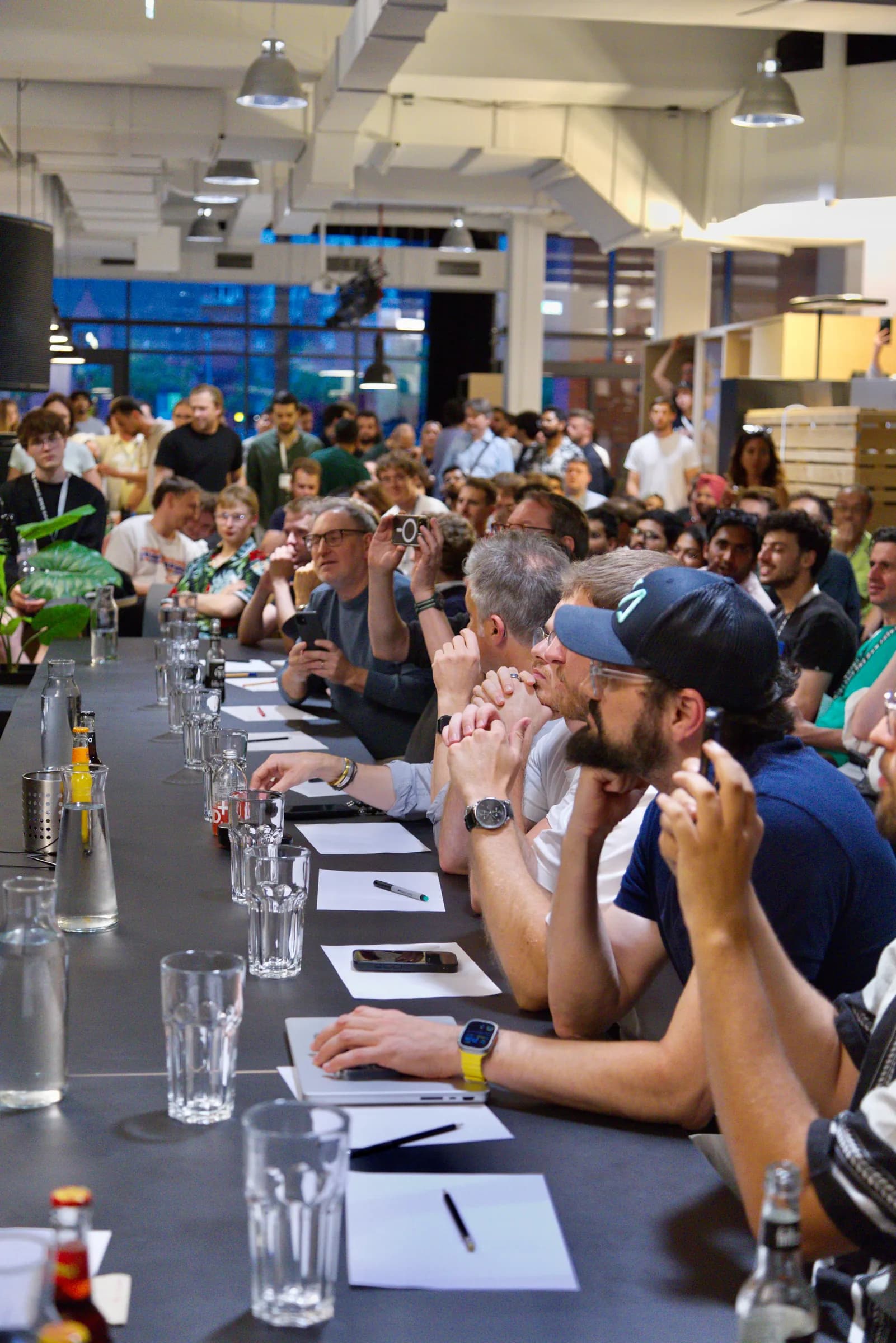 An attendee listening intently among laptops at the AI BEAVERS Founder Hackathon in Hamburg