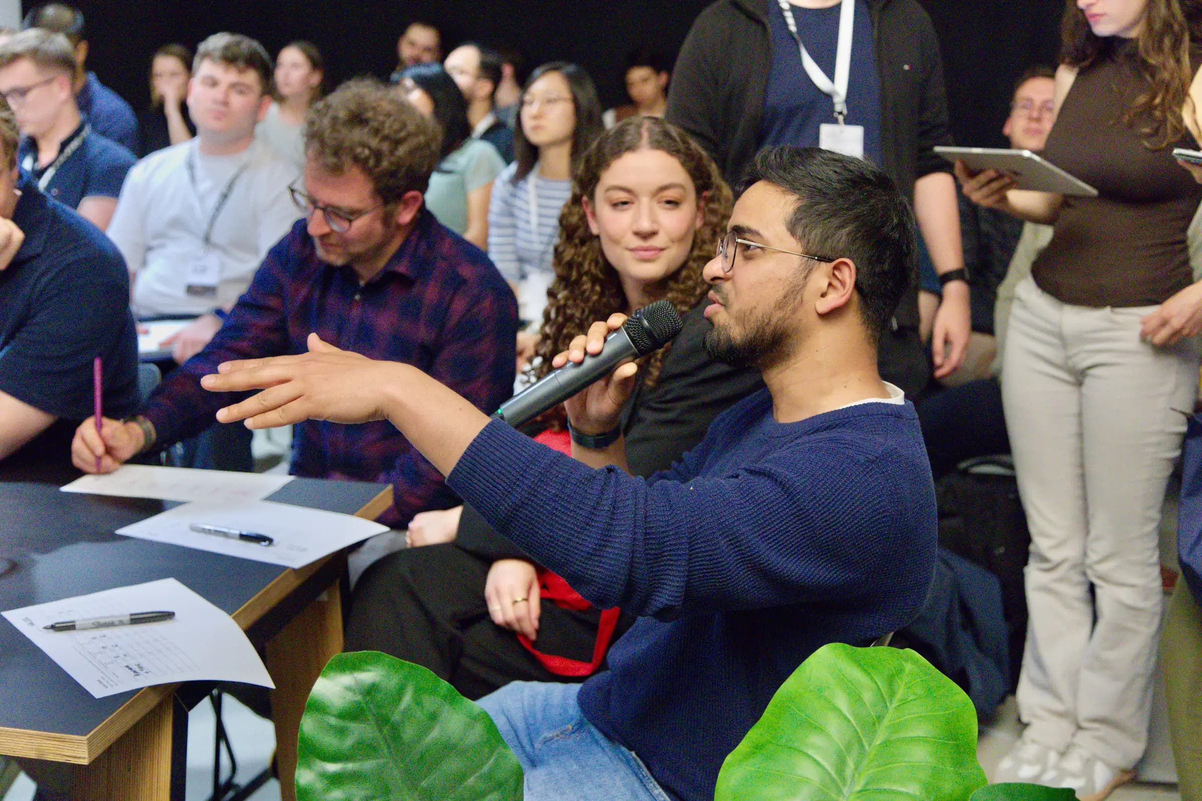 A judge asking a question into a microphone during the pitches at the AI BEAVERS Founder Hackathon in Hamburg