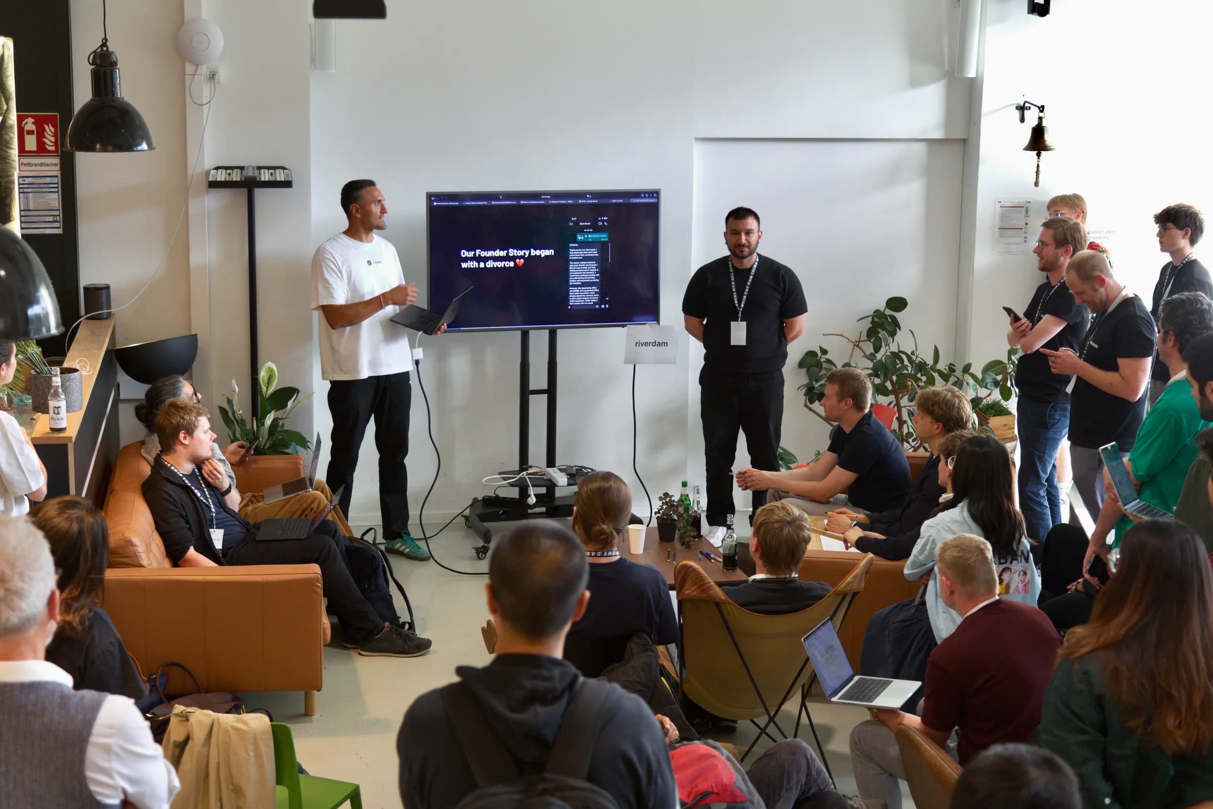 An audience watching a pitch on a large screen at the AI BEAVERS Founder Hackathon in Hamburg