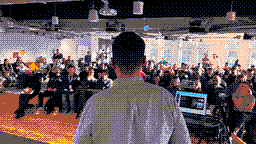A speaker facing a full room at an AI BEAVERS meetup, drawn in pixel art